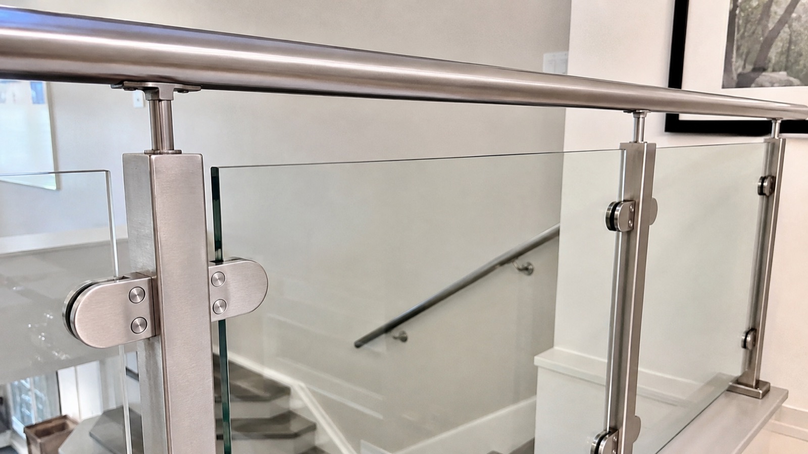 Frameless glass railing with stainless steel standoffs and handrail